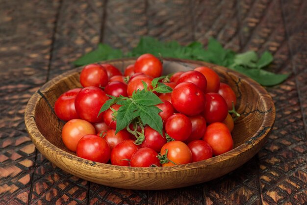 Kleine frische Tomaten in einer Schüssel Kirschtomaten in Schüssel auf rustikalem Tisch