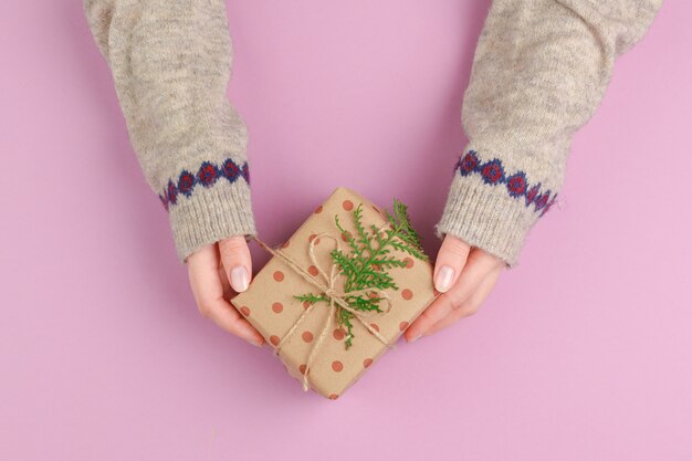 Kleine Geschenkbox in den weiblichen Händen, Ansicht von oben