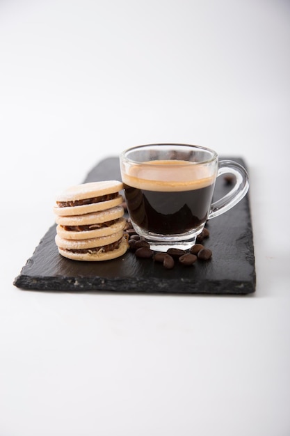 Kleine Glastasse Espresso-Kaffee-Gourmet-Servierung mit Alfajores-Keksen