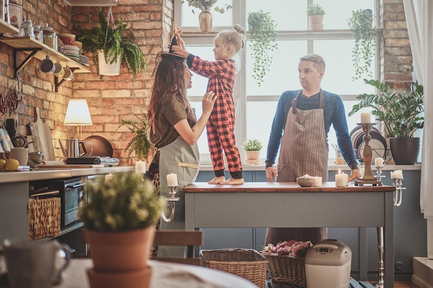 Kleine glückliche familie beginnt ihren gemeinsamen tag in der küche.