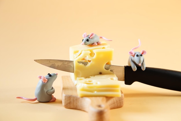 Kleine graue Mäuse aus Plastilin schneiden ein Stück Käse