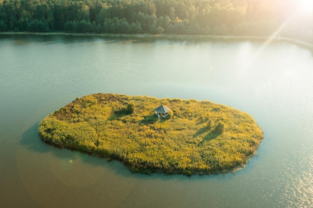 Kleine grüne Insel inmitten der Herbstlandschaft des Sees