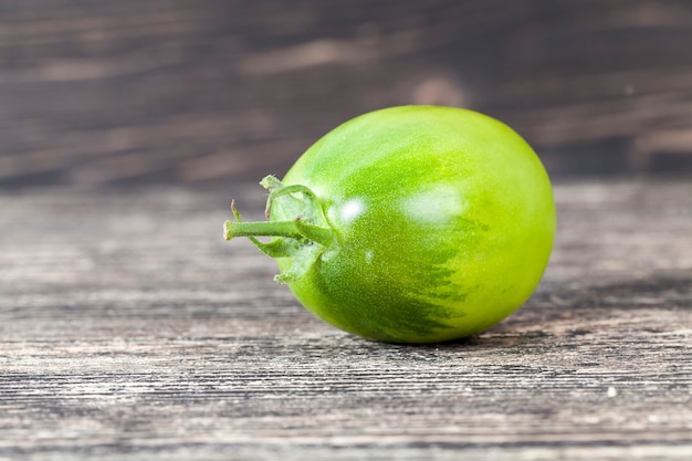 Kleine grüne Tomate auf einem schwarzen Küchentisch