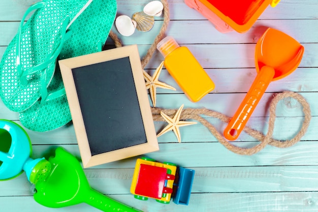 Kleine hölzerne gestaltete leere Tafel mit Strandausrüstung