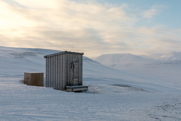 Kleine hölzerne Nebengebäudehütte mitten in arktischer Landschaft im Winter