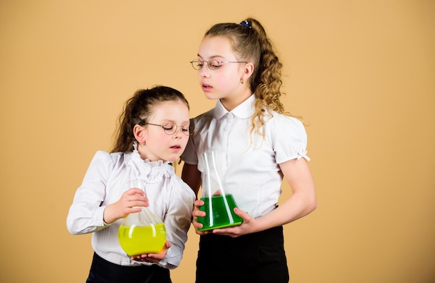 Kleine intelligente Mädchen mit Testflasche. zurück zur Schule. Wissen und Bildung. Kinder lernen im Biologieunterricht. Wissenschaftliche Forschung im Labor. Chemieflasche mit Flüssigkeit. Testflasche in den Händen von Kindern.