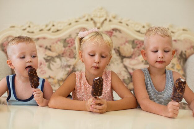 Kleine Jungen und Mädchen, die zu Hause Eis essen