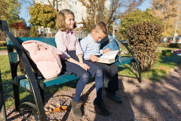 Kleine Jungen und Mädchen Schulkinder lesen Buch