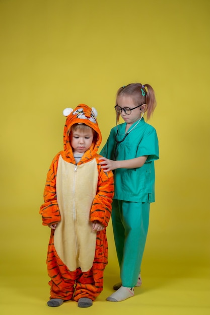 Kleine kaukasische Kinder spielen Arzt, ein Junge in einem Tigerkostüm kam zu einem Termin zum Kinderarzt