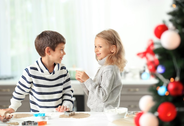 Kleine Kinder, die Weihnachtsplätzchen in der Küche zubereiten