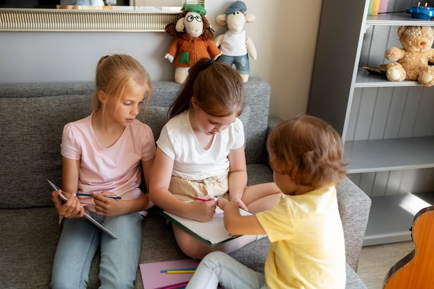 Foto kleine kinder, die zu hause zusammen zeichnen