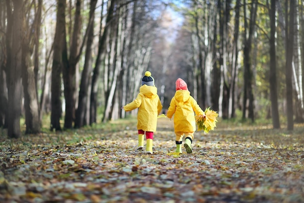 Kleine Kinder gehen im Herbst im Herbstpark spazieren