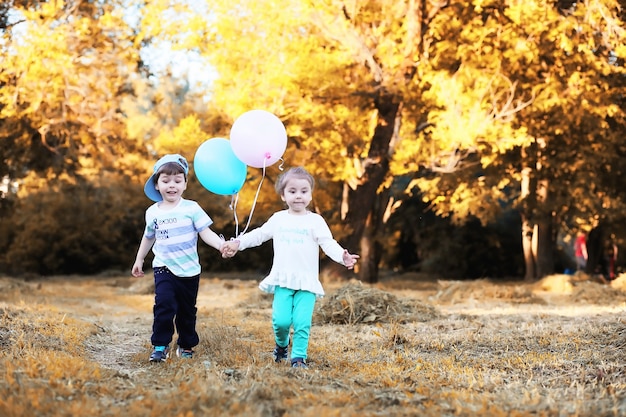 Kleine Kinder gehen im Herbstpark spazieren