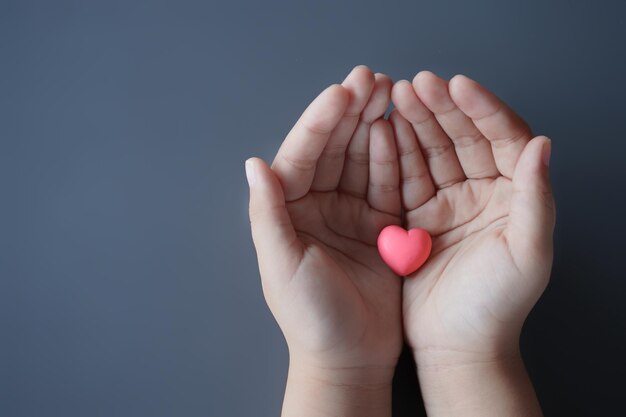 Foto kleine kinder halten ein rosa herz in der hand mit kopierplatz flach legen liebeskonzept