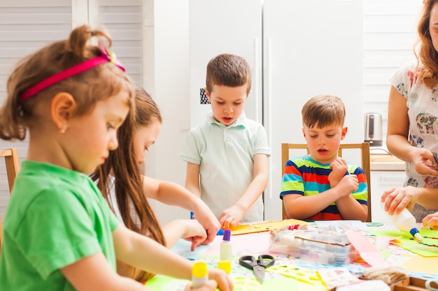 Kleine Kinder in der Meisterklasse, die gemeinsam Grußkarten machen