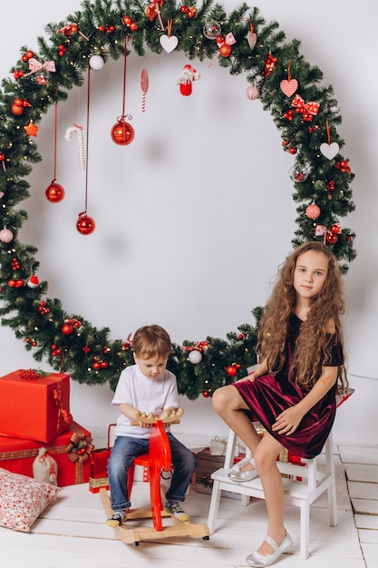 Kleine Kinder in der Nähe von Weihnachtsdekoration