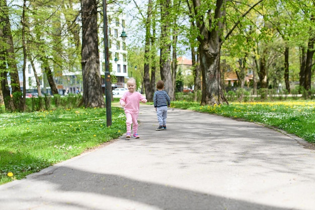 Kleine Kinder laufen in einem Sommerpark