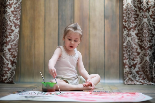 Kleine Kinder malen auf einem großen Blatt Papier