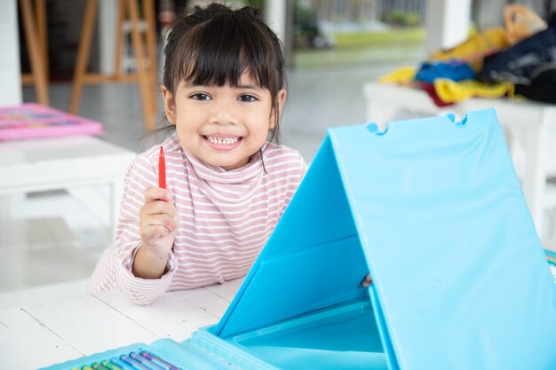 Kleine Kinder zeichnen Cartoon mit einem Farbstift, der eine gute Aktivität zur Verbesserung der kreativen Kunst- und Handschriftfähigkeiten bei Kindern ist. Konzeptbild für Bildung und Lernhobby.