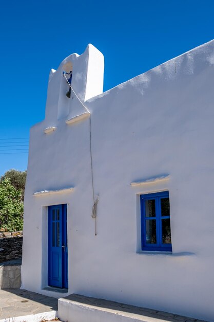 Kleine Kirche, weiße Kapelle und Glockenturm am klaren blauen Himmel Griechenland Kykladeninseln