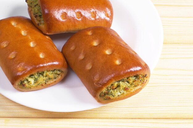 Kleine Kuchen mit Gemüse und Gemüse im Teller auf Holztisch