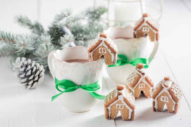 Kleine Lebkuchenhäuschen mit süßem Getränk als Weihnachtssnack