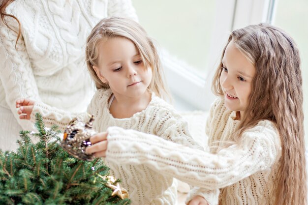 Kleine Mädchen, die den Weihnachtsbaum schmücken