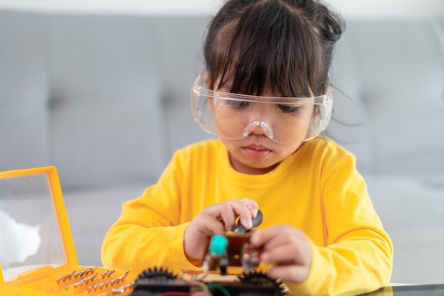 Kleine Mädchen, die Spaß in einem Werkstatt-Codierungsroboterauto haben