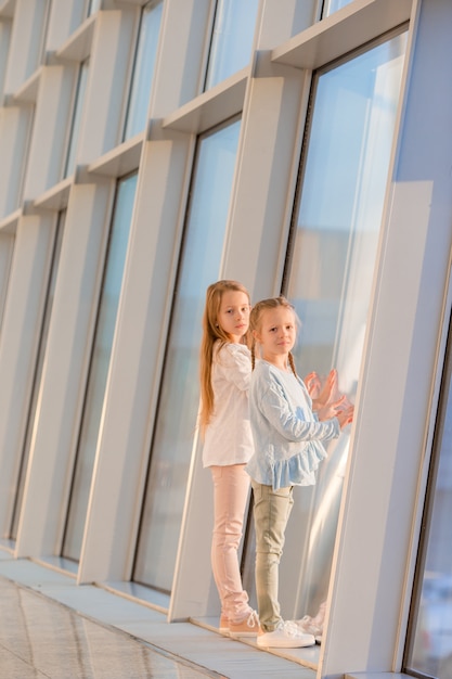 Kleine Mädchen im Flughafen nahe großem Fenster, während Sie auf das Verschalen warten