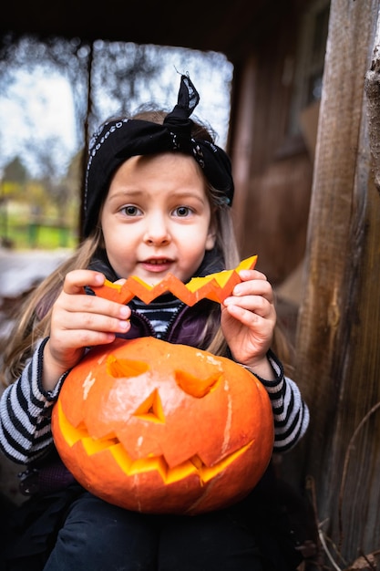 Kleine Mädchen machen Jackolantern aus großen Kürbissen zur Feier des Halloween-Urlaubs