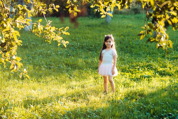 Kleine Mädchen spielen auf grünem Gras im Sommerparkurlaub