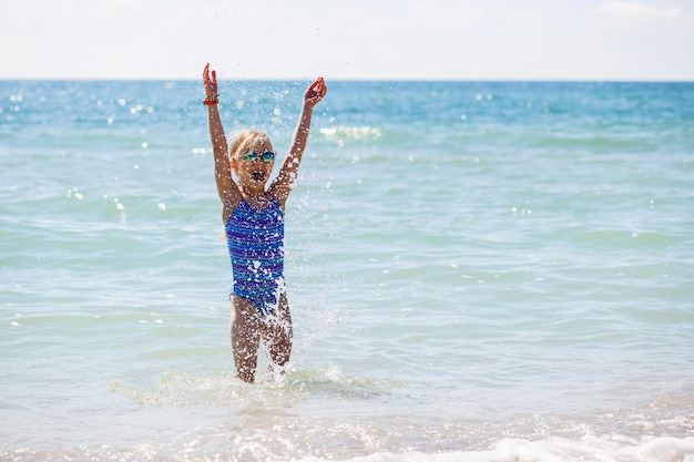 Kleine Mädchen spielen im Urlaub im Wasser