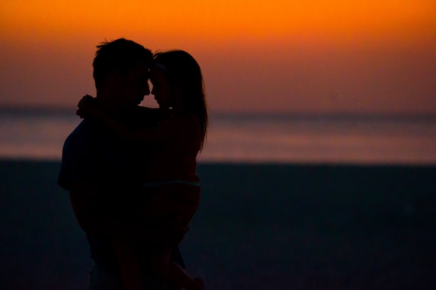 Kleine Mädchen und Papa Silhouette im Sonnenuntergang am Strand