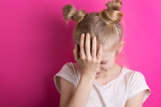 Kleine Mädchenblondine auf einem rosa Hintergrund