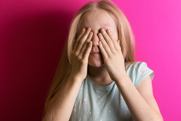 Kleine Mädchenblondine auf einem rosa Hintergrund