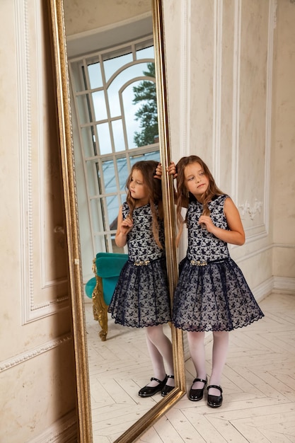 Kleine Mädchenprinzessin 56 Jahre alt, denkendes wegschauendes Modemodell in stilvollem, elegantem blauem Kleid