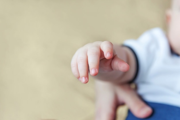 Kleine männliche oder weibliche Babyhand des Neugeborenen, die Mutterfinger hält