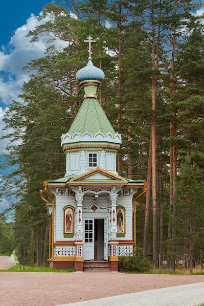 Kleine orthodoxe Holzkirche vor dem Hintergrund von Waldbäumen. Holzkirche im Wald