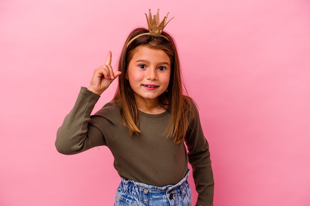 Kleine Prinzessin Mädchen mit Krone lokalisiert auf rosa mit einer Idee