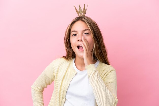 Kleine Prinzessin mit Krone isoliert auf rosa Hintergrund schreit mit weit geöffnetem Mund