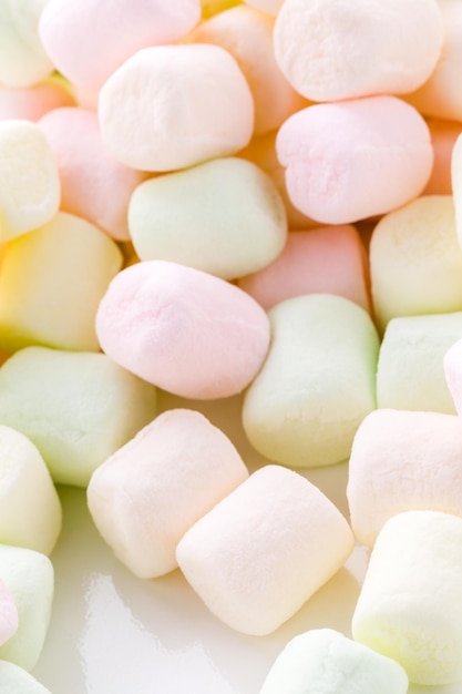 Kleine runde mehrfarbige Marshmallows auf weißem Hintergrund.