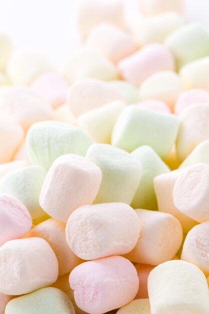 Kleine runde mehrfarbige Marshmallows auf weißem Hintergrund.