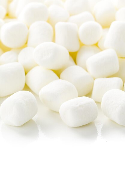 Kleine runde weiße Marshmallows auf weißem Hintergrund.