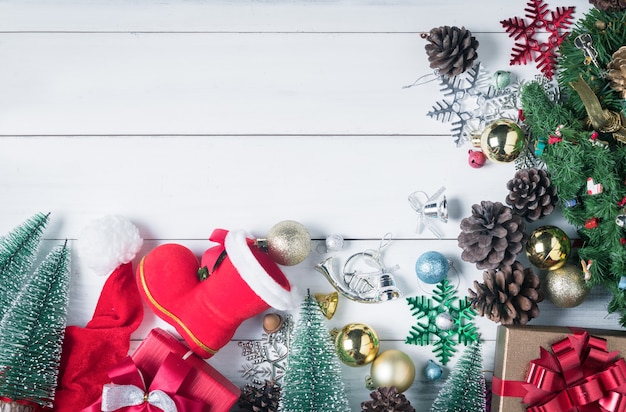 Kleine Santa Cross Schuhe und Weihnachtshintergrund mit Dekorationen auf weißem Holz