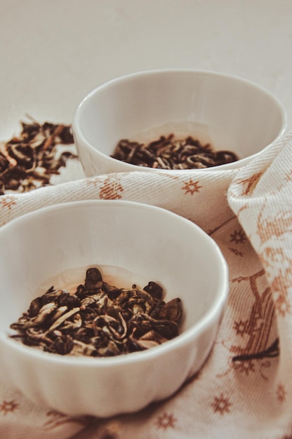 Kleine Schalen mit getrocknetem grünem Tee und Kräutern zur rituellen Reinigung und Reinigung in der Nähe