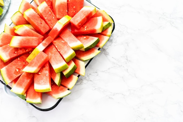 Kleine Scheiben roter kernloser Wassermelone auf dem Tablett für die Party.