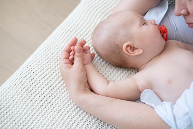 Kleine schlafende Babys Gesicht in Mutterhänden. Mutterschafts- und Kinderbetreuungskonzept. Nippel. Glückliche Familie. Endlose Liebe. stillende Mama. Zu Hause. Liebe. Süss. Zärtlichkeit. Foto in hoher Qualität