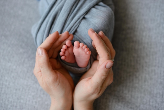 Kleine schöne Beine eines Neugeborenen in den ersten Lebenstagen Babyfüße eines Neugeborenen