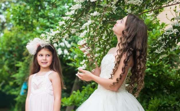 Kleine Schwestern entzückende weiße Kleider Hochzeitsfeier im Konzept der natürlichen Schönheit des Parks