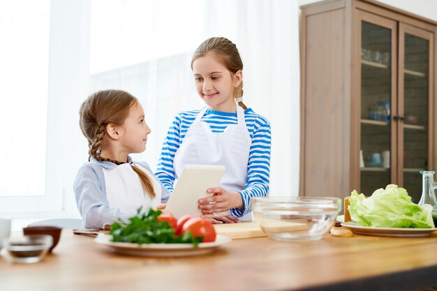 Kleine Schwestern in Kochen eingewickelt